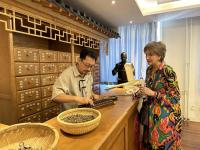 Three individuals learning about eastern medicine techniques and procedures.